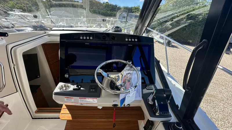 Slide: The Image of 2025 Boston Whaler 405 Conquest helm with modern navigation controls and steering wheel. - 36