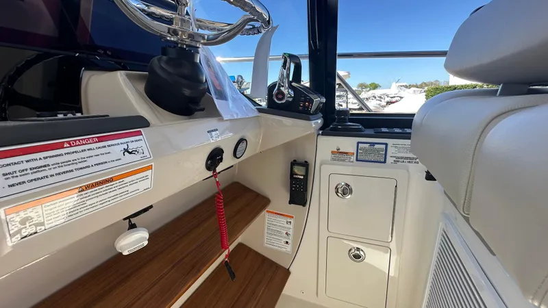 Slide: The Image of 2025 Boston Whaler 405 Conquest helm with controls and storage compartments. - 37