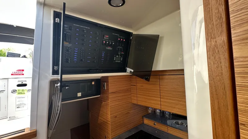 Slide: The Image of Interior of 2025 Boston Whaler 405 Conquest with control panel and wooden cabinetry. - 41