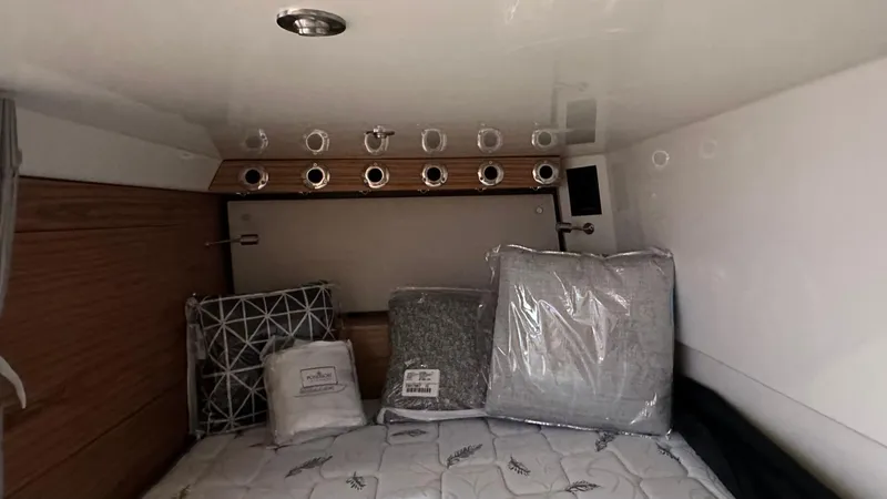 Slide: The Image of 2025 Boston Whaler 405 Conquest cabin interior with bedding and storage. - 45