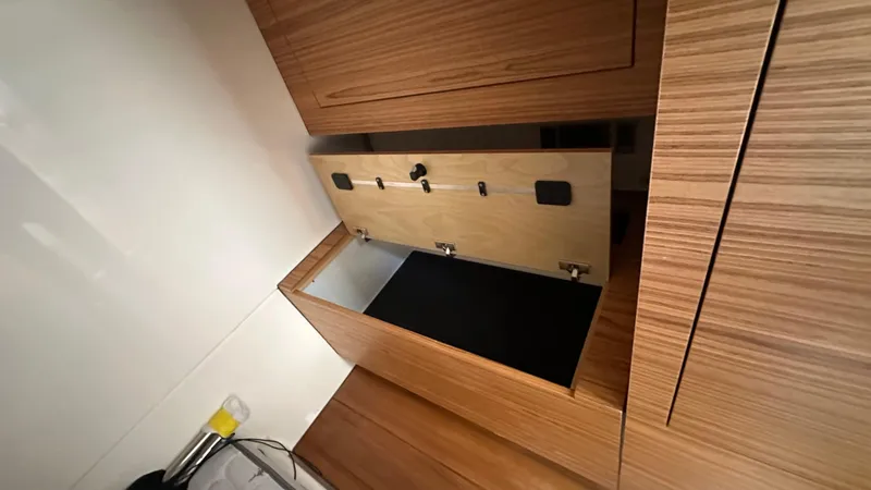 Slide: The Image of 2025 Boston Whaler 405 Conquest interior storage compartment with wooden finish. - 46
