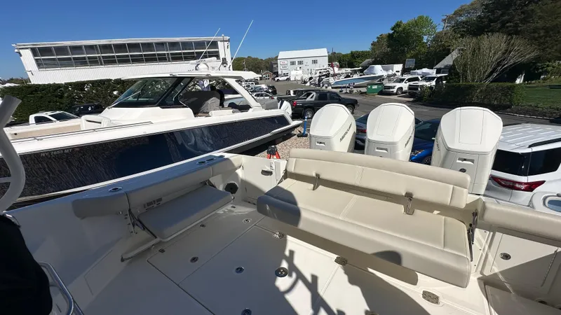 Slide: The Image of 2025 Boston Whaler 405 Conquest boat with seating and outboard motors in a marina setting. - 5