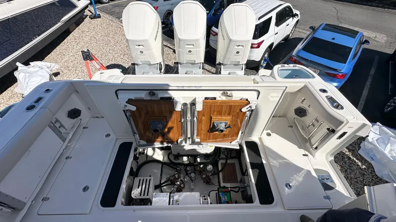 Slide: The Image of 2025 Boston Whaler 405 Conquest boat deck with open engine compartment, showcasing triple outboard motors. - 7
