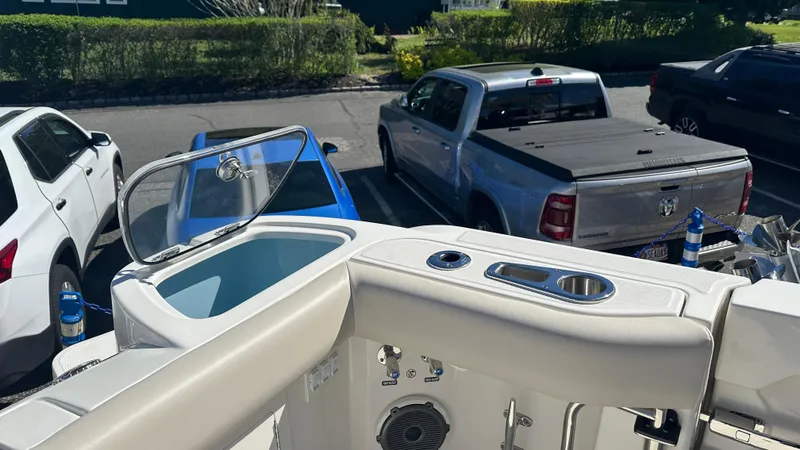 Slide: The Image of 2025 Boston Whaler 405 Conquest boat interior with parked cars in the background. - 9