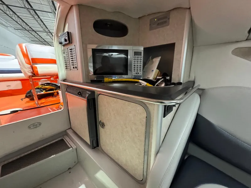 Slide: The Image of 2007 Baja 35 Outlaw interior with kitchenette, featuring microwave and storage cabinets. - 20
