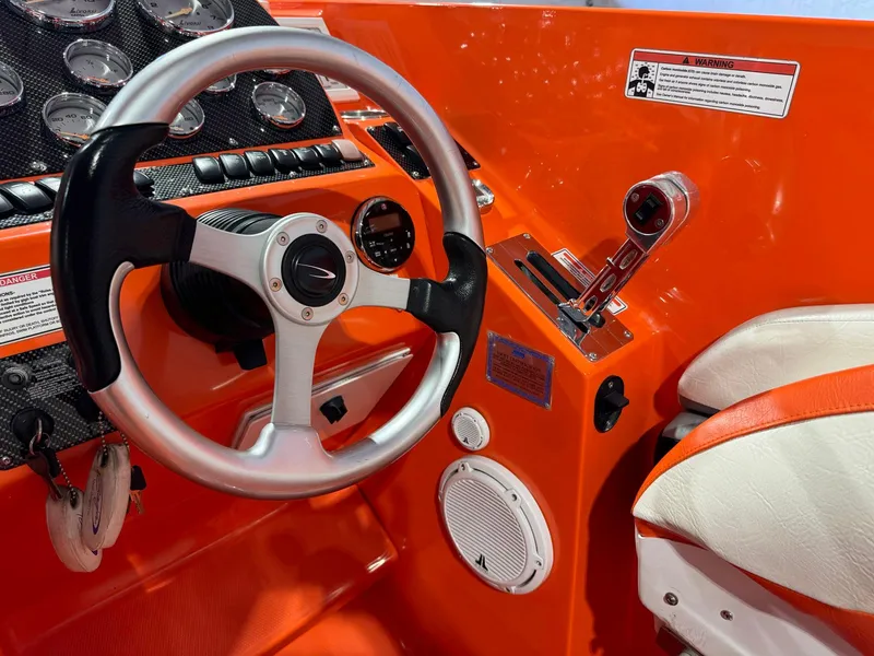 Slide: The Image of 2007 Baja 35 Outlaw boat cockpit with orange dashboard and steering wheel. - 7