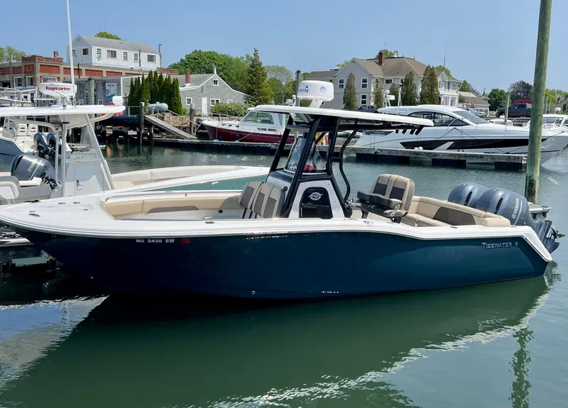 Slide: The Image of 2020 Tidewater 252 LXF boat docked in a marina, featuring sleek design and dual engines. - 0