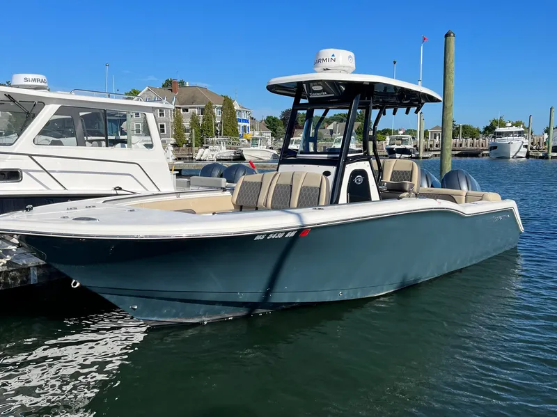 Slide: The Image of 2020 Tidewater 252 LXF boat docked in marina, clear blue sky background. - 1