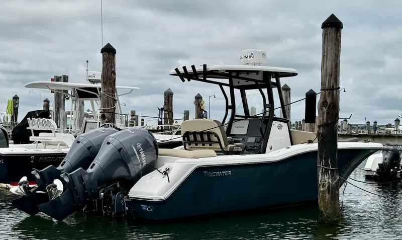 Slide: The Image of 2020 Tidewater 252 LXF boat docked with twin outboard engines under cloudy skies. - 3