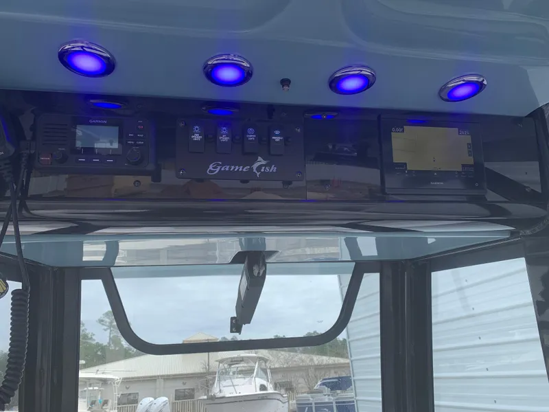 Slide: The Image of 2020 Sea Hunt Gamefish 27 dashboard with blue LED lights and navigation controls. - 18