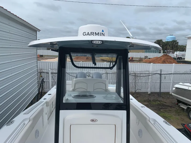 Slide: The Image of 2020 Sea Hunt Gamefish 27 boat with Garmin equipment, docked near a construction site. - 2