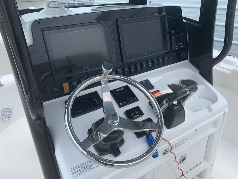 Slide: The Image of 2020 Sea Hunt Gamefish 27 helm with dual screens and steering wheel. - 9