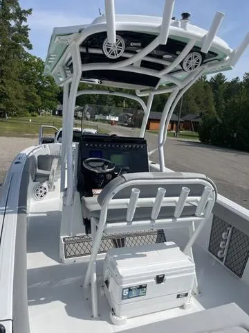 Slide: The Image of 2023 Wellcraft 242 Fisherman boat interior with helm and seating, parked outdoors. - 3