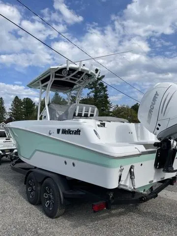 Slide: The Image of 2023 Wellcraft 242 Fisherman boat with Mercury engine on trailer, under cloudy sky. - 6
