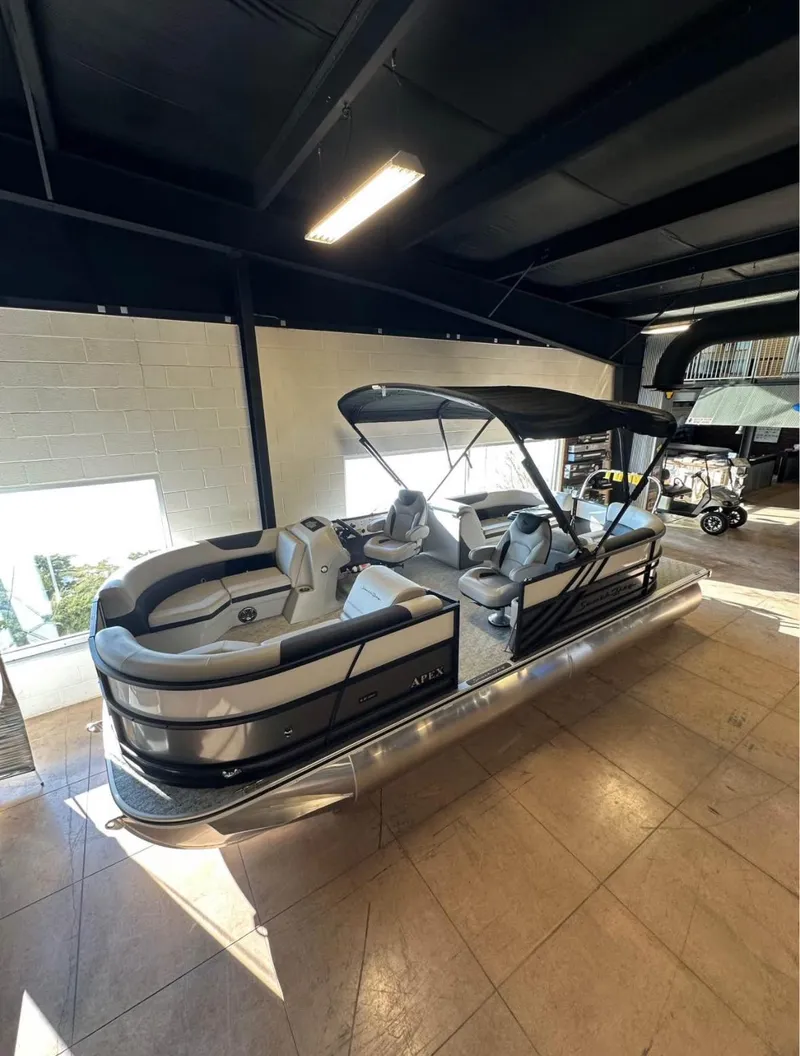 Slide: The Image of 2025 South Bay 222 RS LE Apex Edition pontoon boat in showroom. - 2