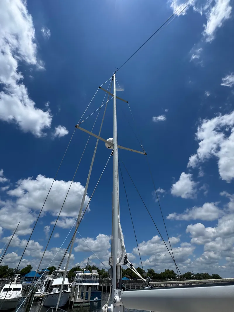 Slide: The Image of 1981 Gulfstar 44 sailboat mast against a bright blue sky with clouds. - 12