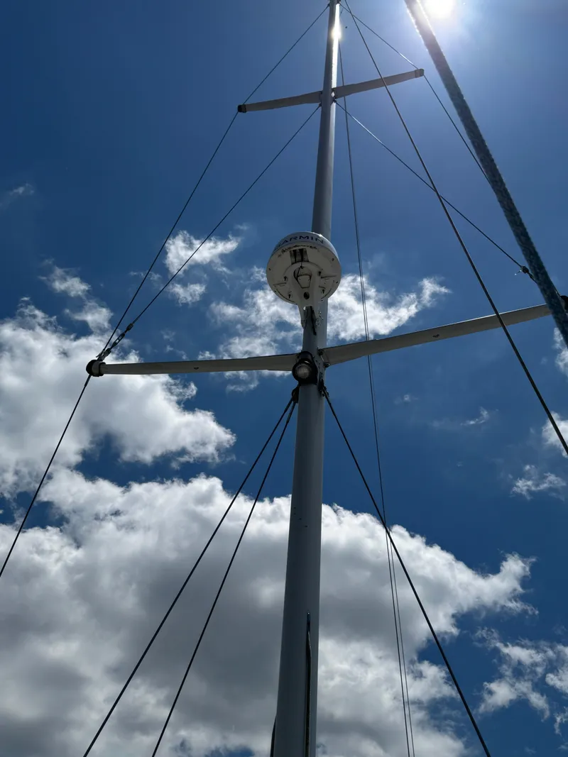Slide: The Image of Mast of 1981 Gulfstar 44 sailboat against a bright blue sky with clouds. - 2
