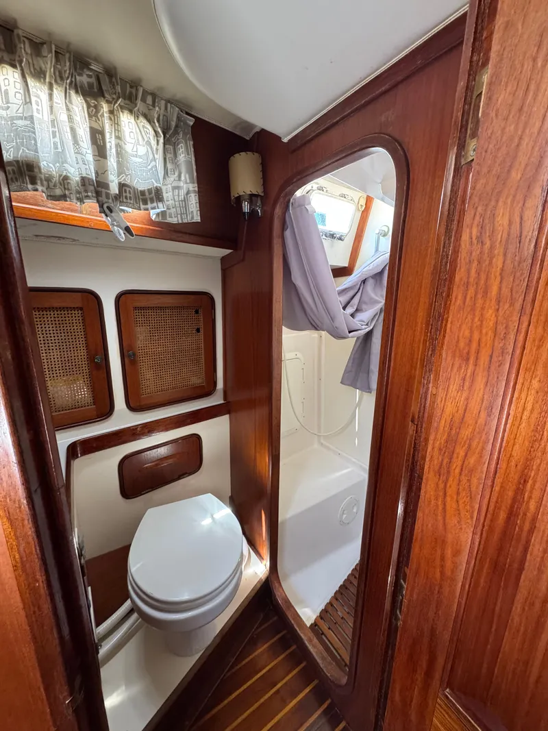 Slide: The Image of 1981 Gulfstar 44 yacht bathroom with wooden cabinetry and compact toilet. - 26