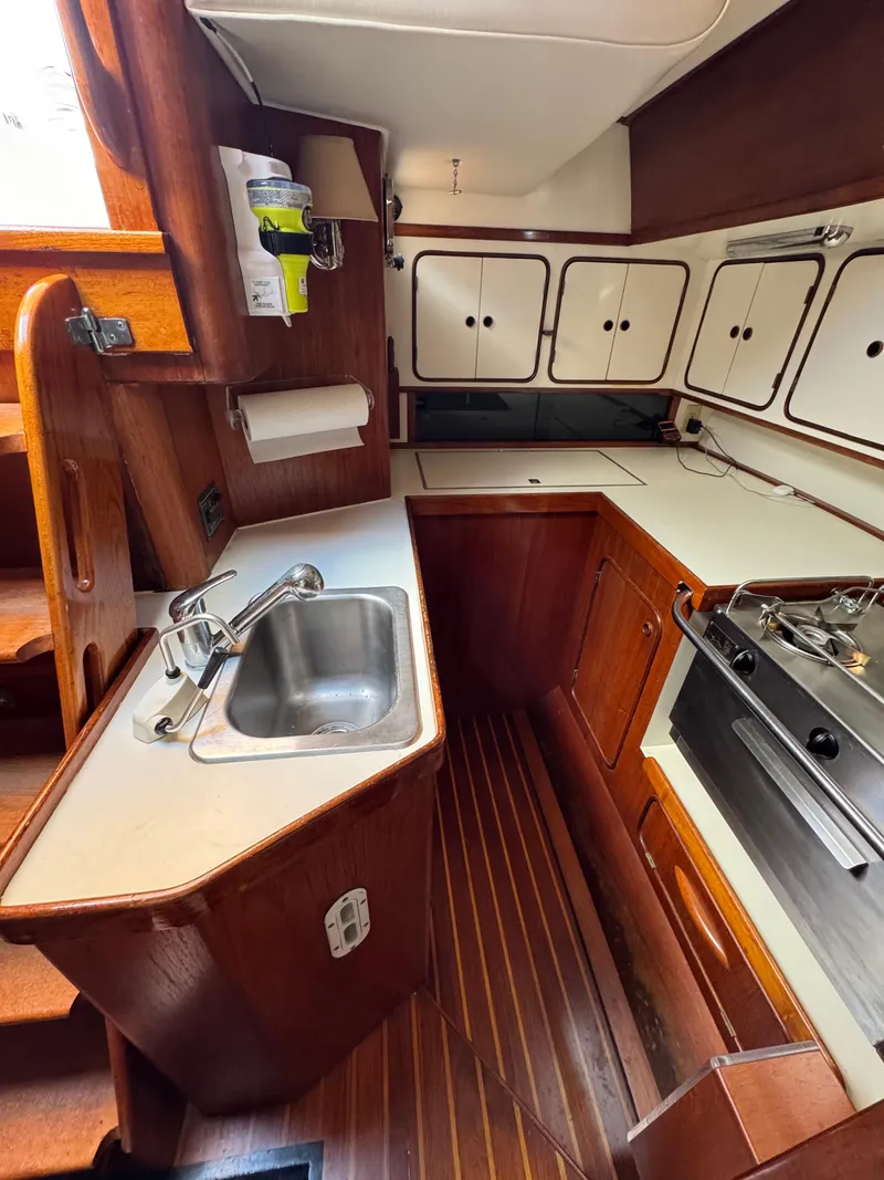 Slide: The Image of 1981 Gulfstar 44 yacht kitchen with wooden cabinetry, sink, and stove. - 29