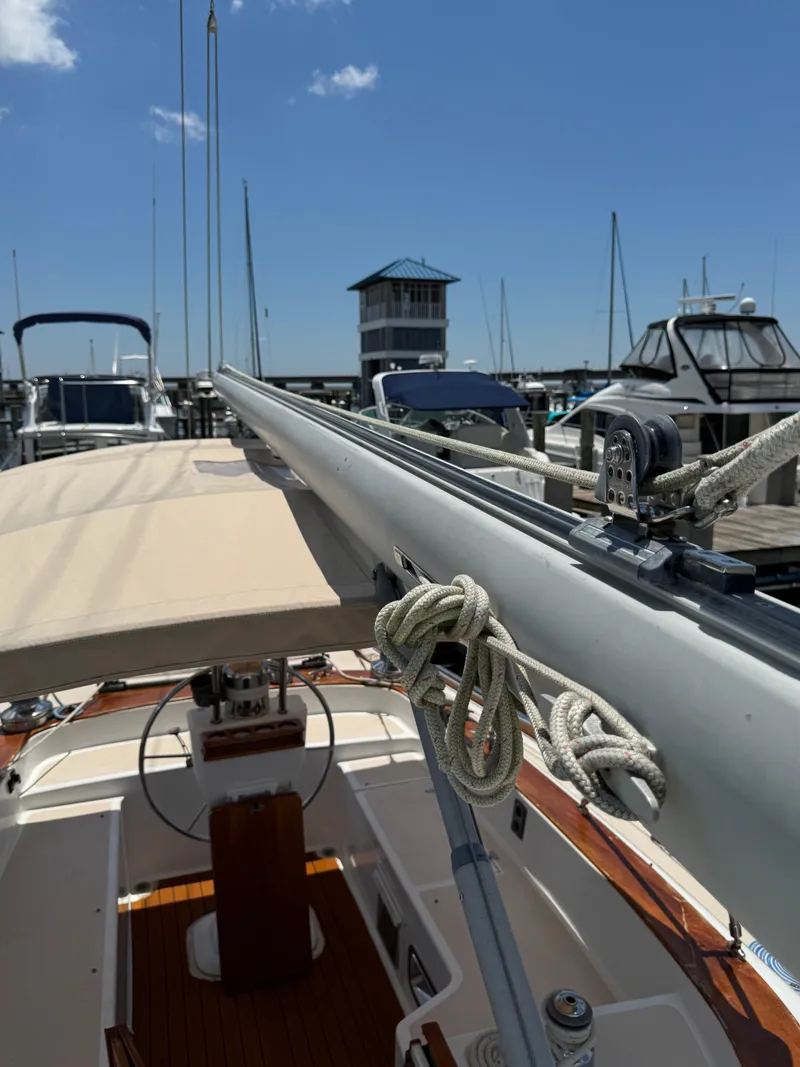 Slide: The Image of 1981 Gulfstar 44 sailboat docked at marina, clear sky, visible rigging and helm. - 4