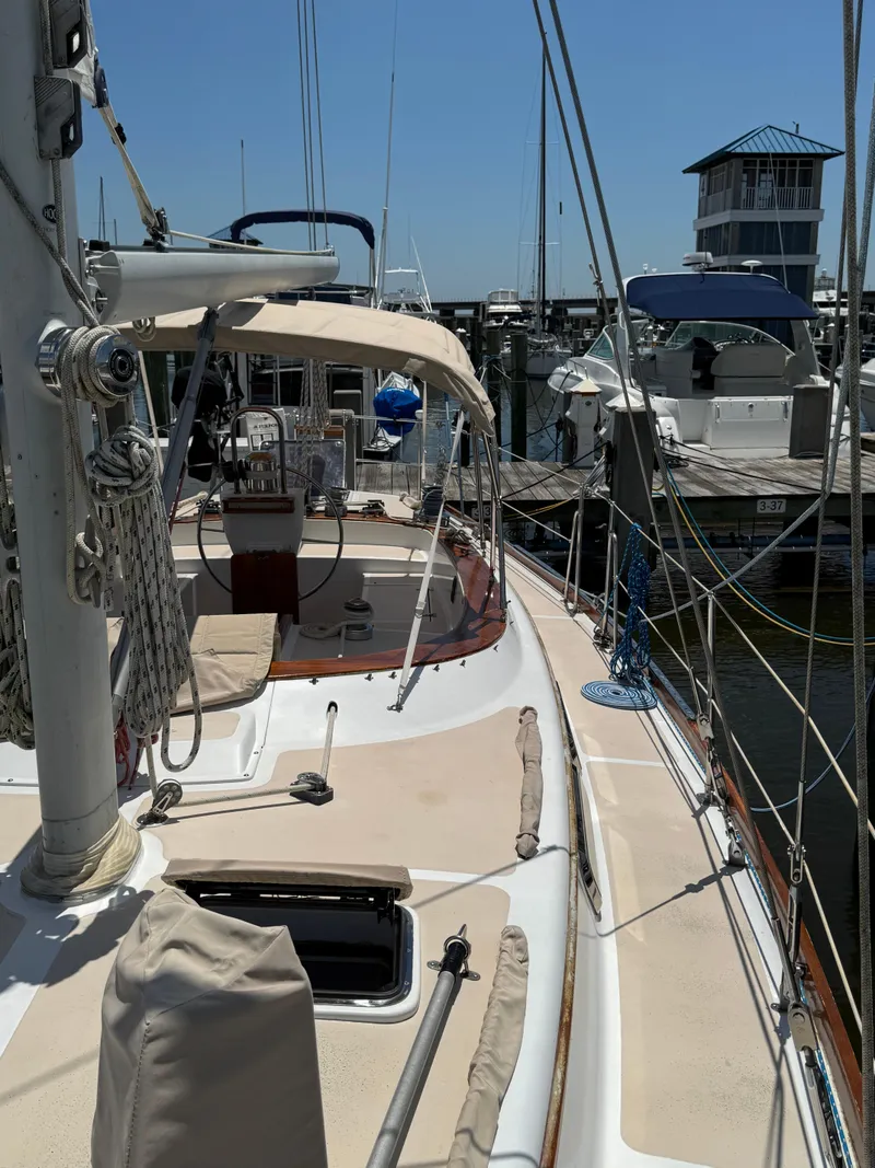 Slide: The Image of 1981 Gulfstar 44 sailboat docked at marina, featuring spacious deck and rigging. - 8