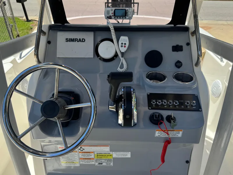 Slide: The Image of 2022 Bayliner Trophy T20CC boat console with steering wheel and controls. - 3