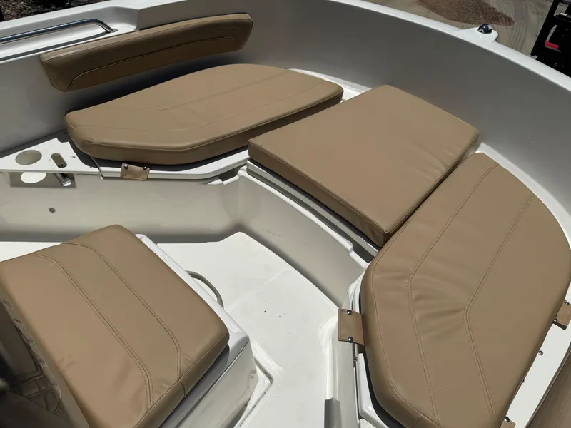 Slide: The Image of 2022 Bayliner Trophy T20CC boat with beige cushioned seating in the bow area. - 6