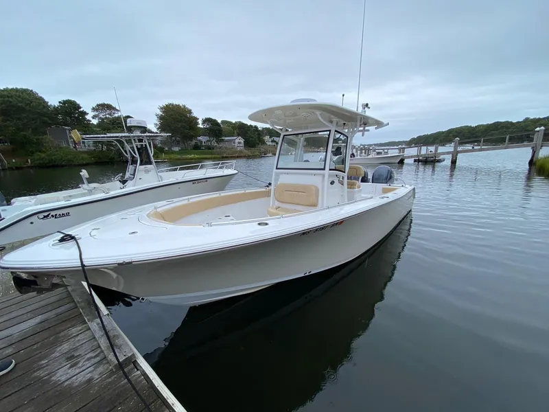 Slide: The Image of 2018 Sportsman Heritage 251 Center Console boat docked on calm water. - 2