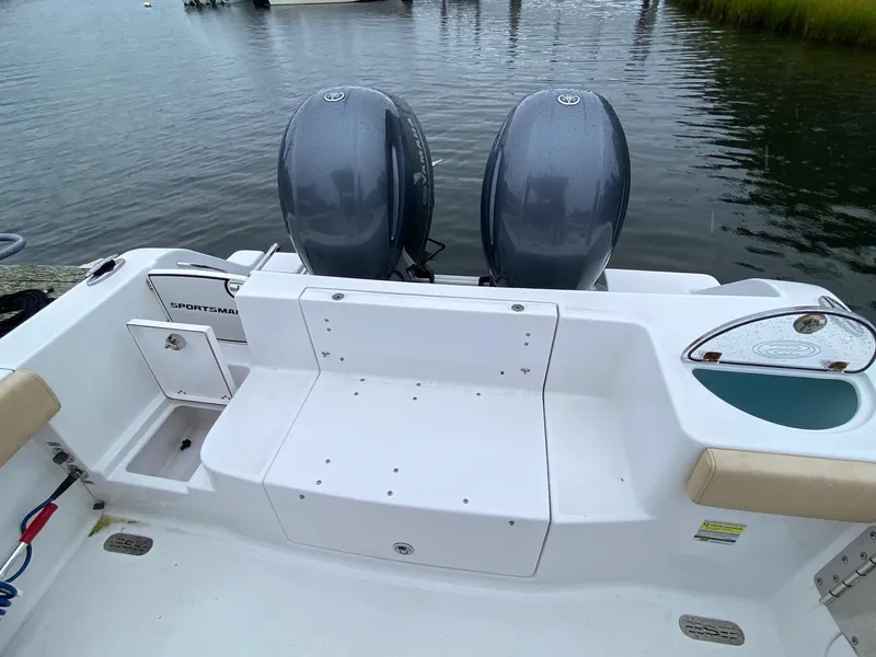 Slide: The Image of 2018 Sportsman Heritage 251 Center Console boat with dual engines on calm water. - 21