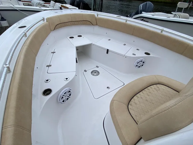 Slide: The Image of 2018 Sportsman Heritage 251 Center Console boat interior with beige seating and storage compartments. - 24