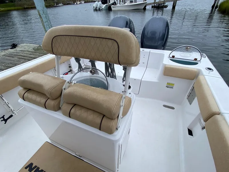 Slide: The Image of 2018 Sportsman Heritage 251 Center Console boat interior with tan seating and dual engines. - 27