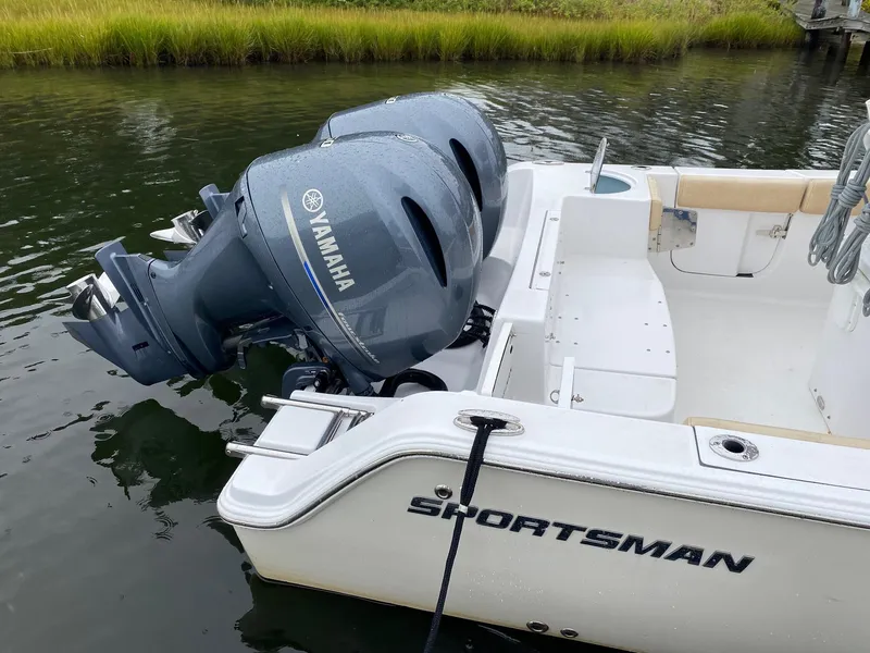 Slide: The Image of 2018 Sportsman Heritage 251 Center Console with Yamaha outboard engines docked on calm water. - 28