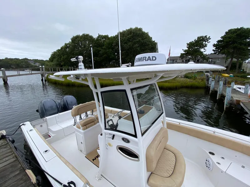 Slide: The Image of 2018 Sportsman Heritage 251 Center Console boat docked by a scenic waterfront. - 30