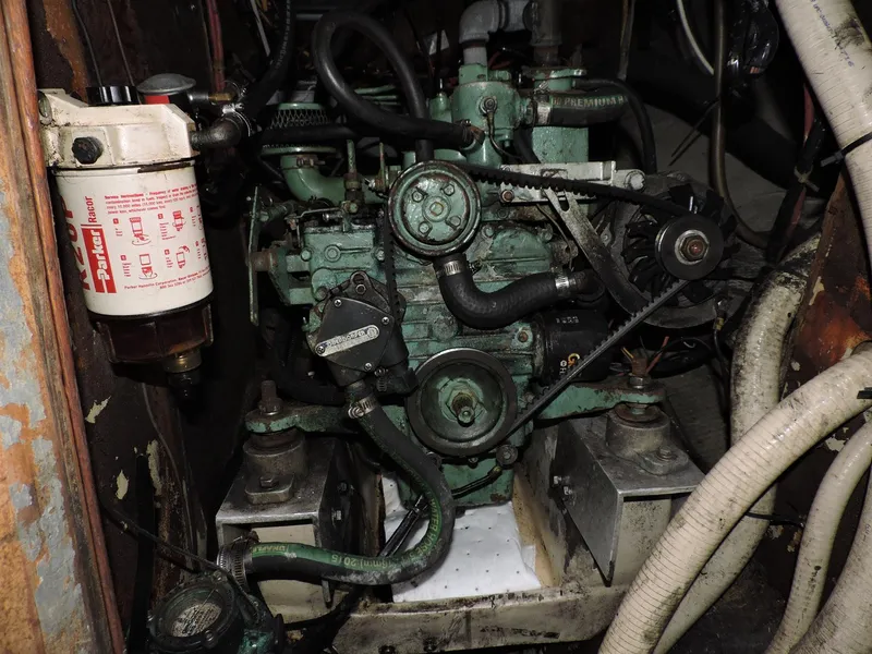 Slide: The Image of Engine compartment of a 1982 Custom Wings 33 Ketch sailboat, featuring mechanical components and hoses. - 12
