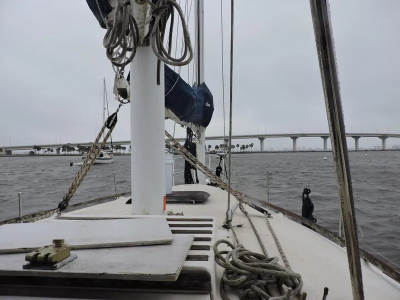 Slide: The Image of 1982 Custom Wings 33 Ketch sailboat on water, bridge in background, overcast sky. - 16