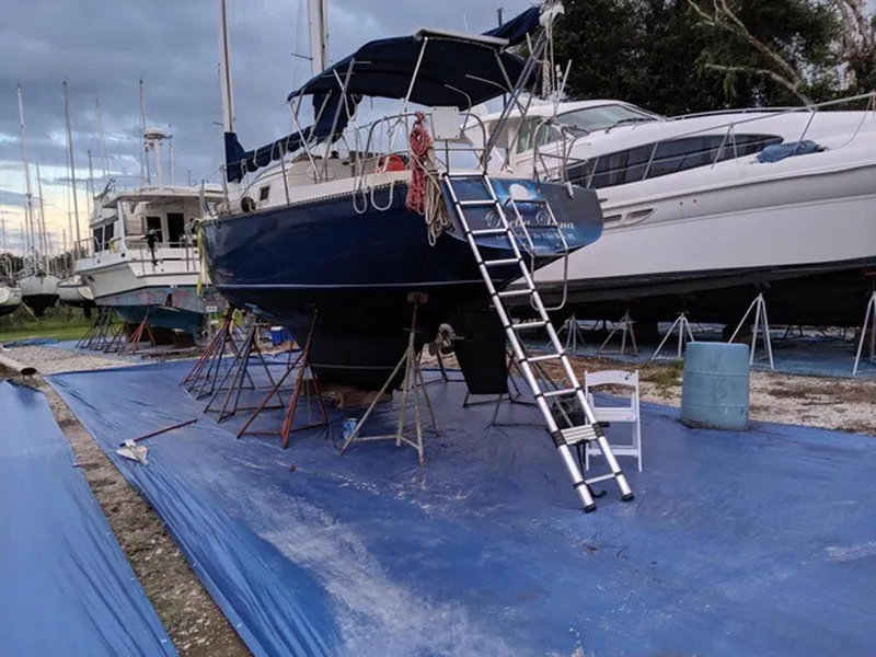 Slide: The Image of 1982 Custom Wings 33 Ketch sailboat on stands, with ladder and blue tarp. - 18