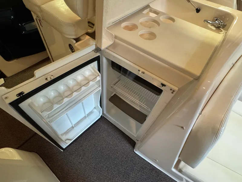 Slide: The Image of 2004 Tiara Yachts 3600 Sovran interior with open mini fridge and cup holders. - 10