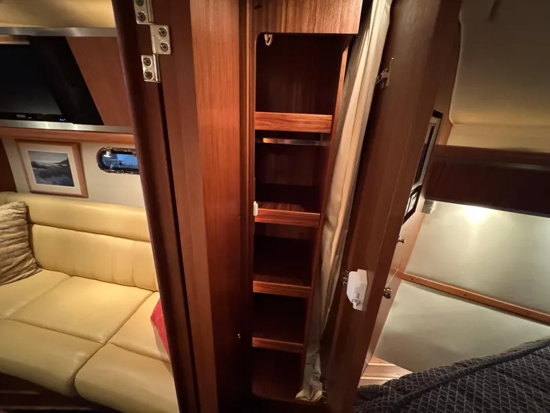 Slide: The Image of 2004 Tiara Yachts 3600 Sovran interior with wooden shelving and beige seating. - 27