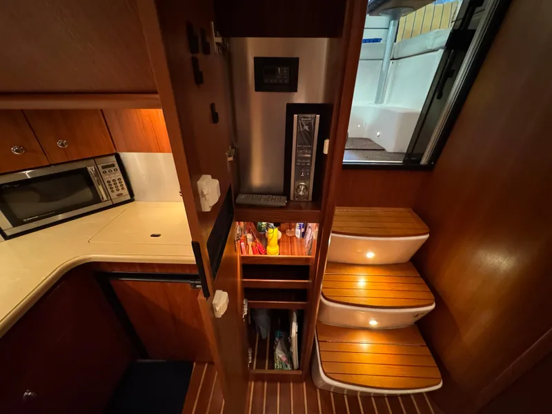 Slide: The Image of 2004 Tiara Yachts 3600 Sovran interior with kitchenette, microwave, and wooden steps. - 28