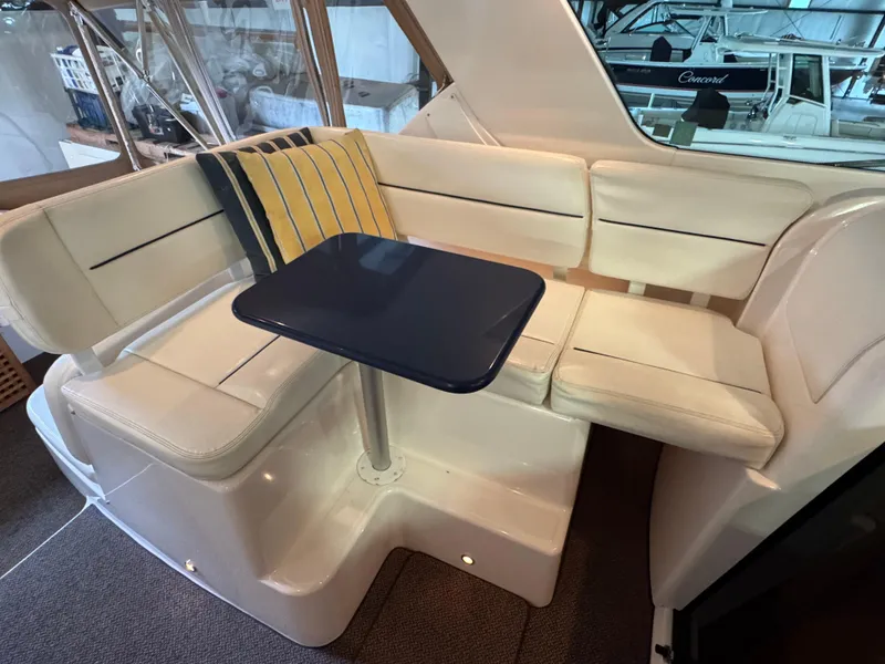 Slide: The Image of 2004 Tiara Yachts 3600 Sovran interior seating with table and cushion. - 8