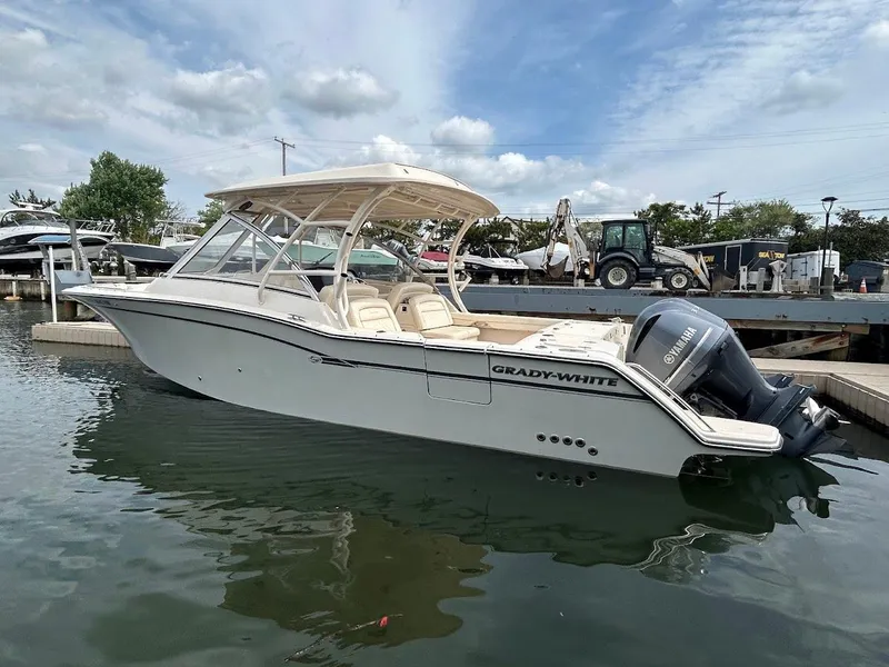 Slide: The Image of 2019 Grady-White Freedom 325 boat docked in marina, featuring sleek design and Yamaha outboard engine. - 2