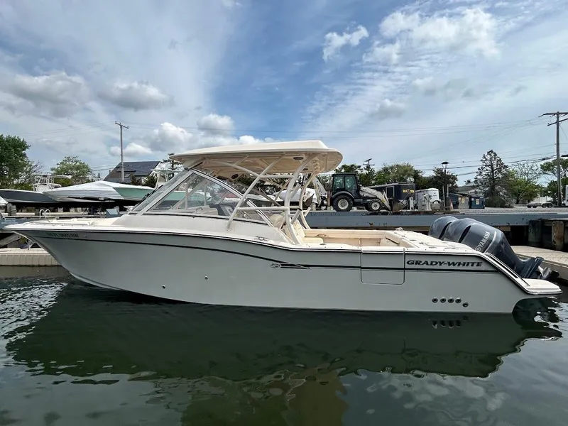 Slide: The Image of 2019 Grady-White Freedom 325 boat docked in marina under cloudy sky. - 3