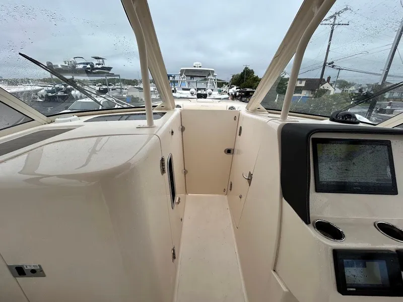 Slide: The Image of 2019 Grady-White Freedom 325 boat interior with navigation screens and windshield view. - 5