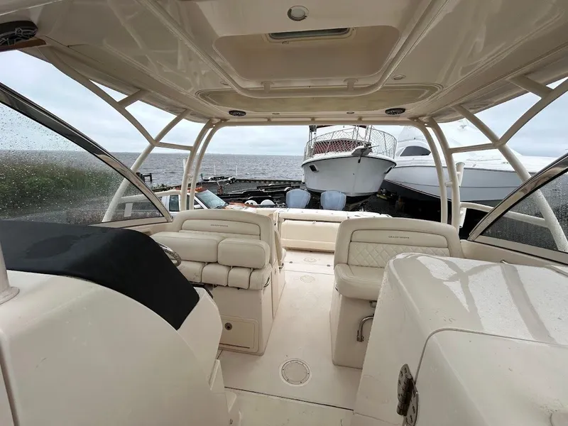 Slide: The Image of 2019 Grady-White Freedom 325 boat interior with seating, docked near other vessels. - 8