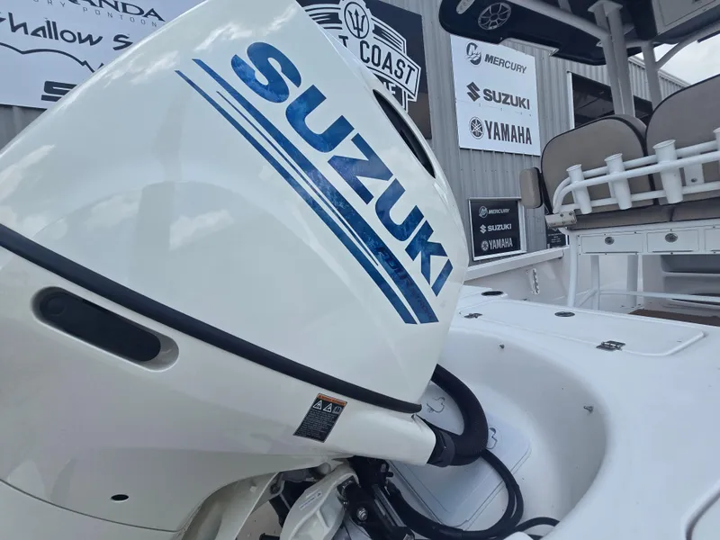Slide: The Image of 2021 Sea Pro 228 Bay with Suzuki outboard motor, displayed at a dealership. - 10