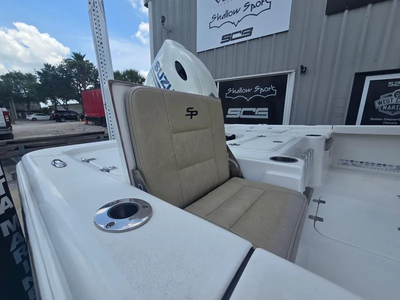 Slide: The Image of 2021 Sea Pro 228 Bay boat with tan seating and cup holders, displayed outdoors. - 12