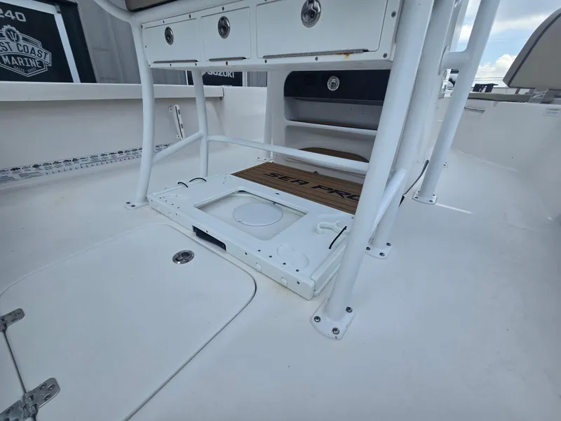 Slide: The Image of 2021 Sea Pro 228 Bay boat interior, featuring storage compartments and seating area. - 13