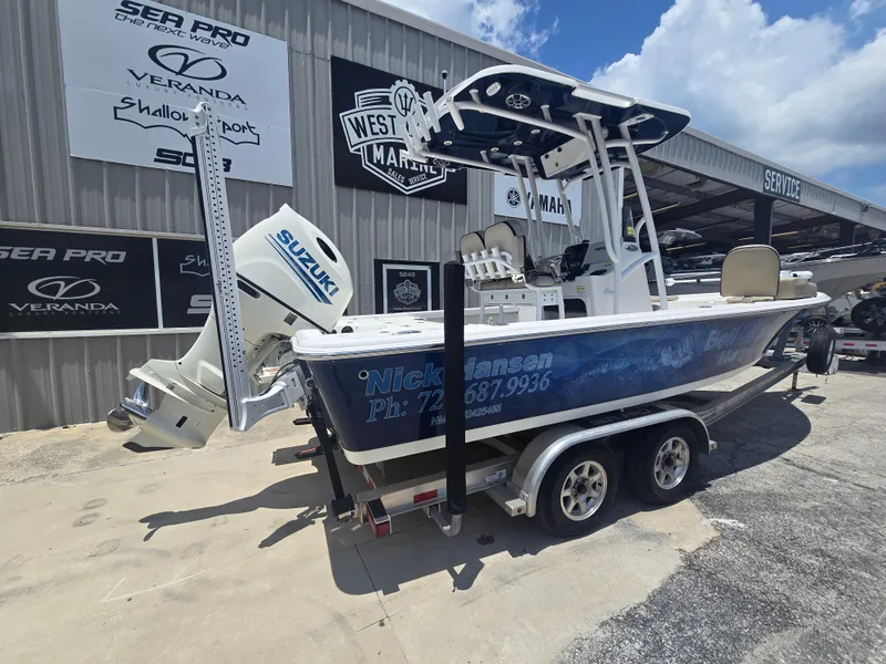 Slide: The Image of 2021 Sea Pro 228 Bay boat on trailer, displayed at dealership with Suzuki outboard motor. - 3