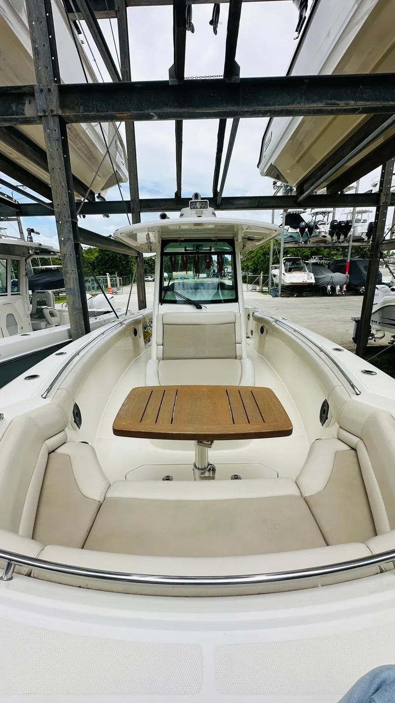 The Image of 2020 Boston Whaler 330 Outrage boat with seating and table in marina setting. - 1