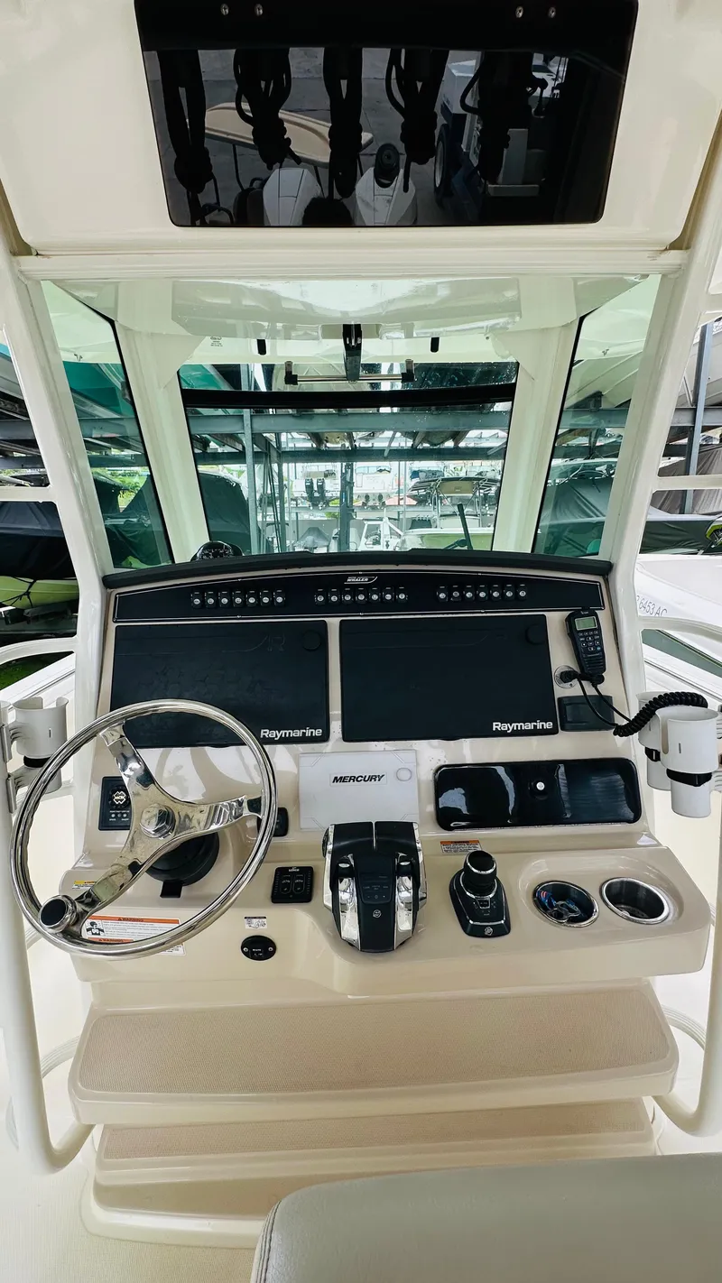 Slide: The Image of 2020 Boston Whaler 330 Outrage helm with steering wheel and navigation controls. - 11